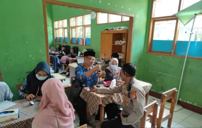 Polsek Banjarwangi Ikut Donor Darah Dalam Rangka HUT.PGRI Ke 80 Di SDN Banjarwangi 1